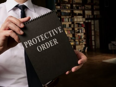 man holding a paper with the text Protective Order