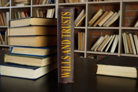 books piled up with one book saying Wills and Trusts