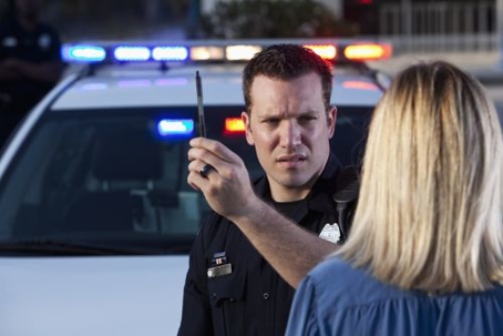 police officer performing a sobriety test to a woman